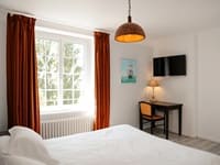 Vue d'une chambre d'hôtes confortable et lumineuse, aménagée pour le repos des randonneurs